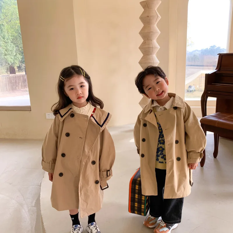 	
two kids stacked in a trench coat